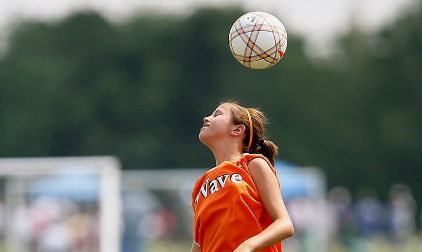 menyundul bola